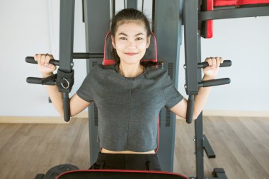 Asyalı kadın omuz basın makine spor salonunda egzersiz