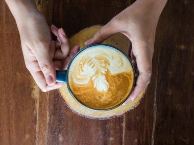 Yüzüklü bardak kahve rustik ahşap masa arka planda tutan eller