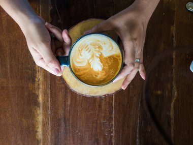 Yüzüklü bardak kahve rustik ahşap masa arka planda tutan eller