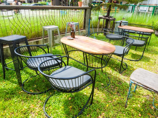 Table et chaises en bois debout sur une pelouse — Photo