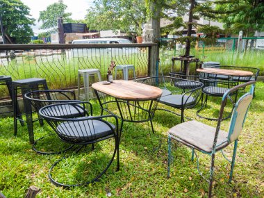 Ahşap masa ve sandalyeler bir çim üzerinde duran