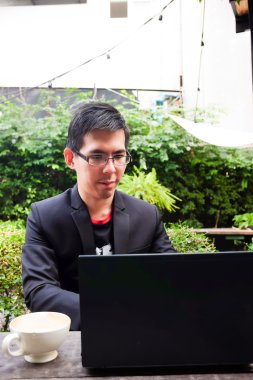 Dizüstü bilgisayarda kahve dükkanında çalışan Asya yakışıklı genç 