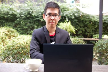 Genç adam kafede dizüstü ile çalışma