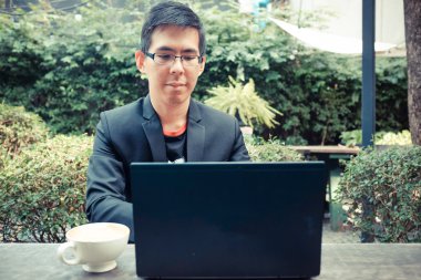 Dizüstü bilgisayarda kahve dükkanında çalışan Asya yakışıklı genç 