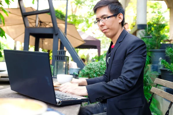 Kafede Elinde Kahve Fincanıyla Dizüstü Bilgisayarda Çalışan Asyalı Adamı — Stok fotoğraf