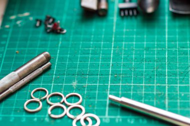 Deri el sanatları araçları yeşil kesici kurulu arka plan, fotoğraf makinesi kayışı ürün üzerinde