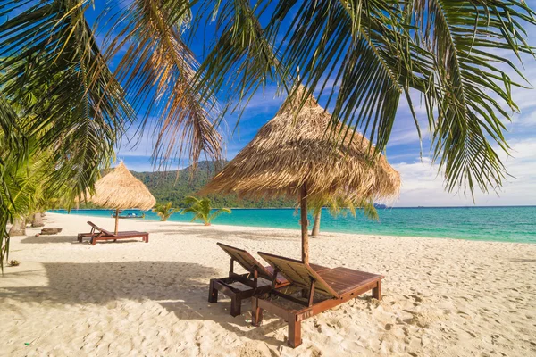 Tiempo de vacaciones fondo de dos sillas de salón de playa bajo la hierba — Foto de Stock