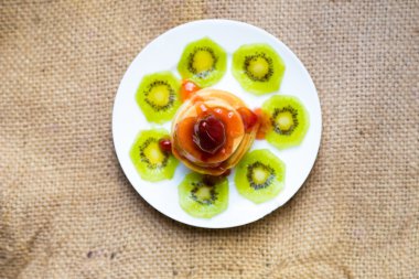 Tereyağı ve beyaz tabak meyve ile Pancakes