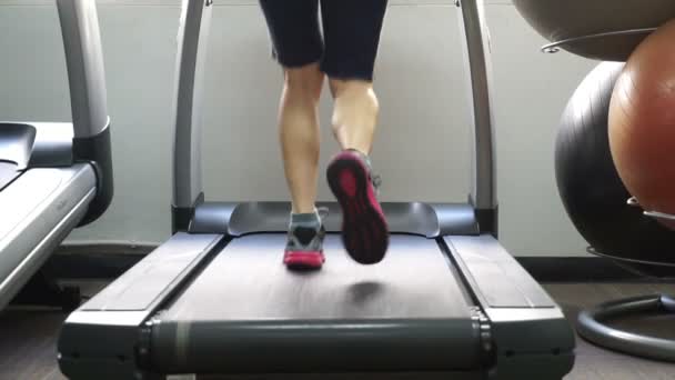 在体育馆里的跑步机上行走的女人的剪影 — 图库视频影像