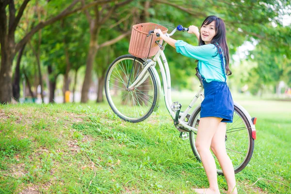 緑豊かな公園で自転車の若い笑顔美人 — ストック写真