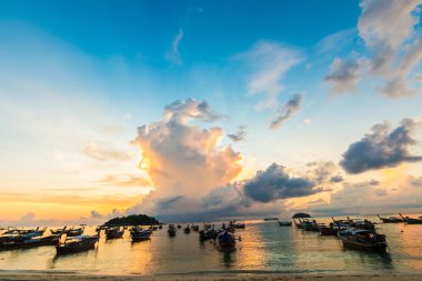 Balıkçı teknesi sahil siluet günbatımı hafif renkli bulut