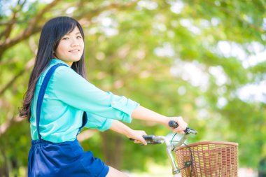 Güzel genç gülümseyen kadın Bisiklet yeşil park