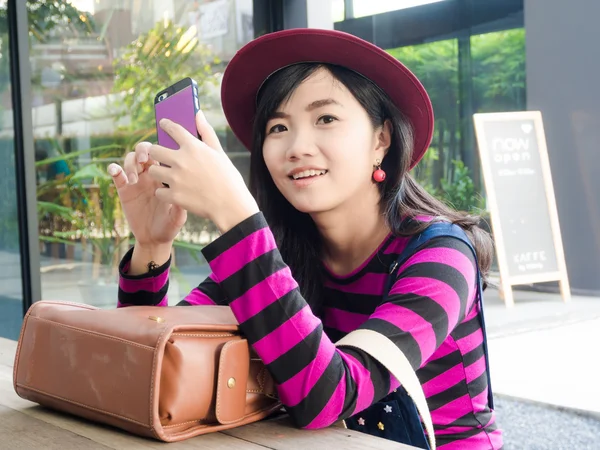 Улыбающаяся азиатка с мобильного смартфона . — стоковое фото