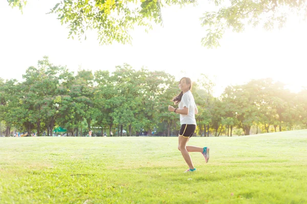 年轻的健身亚洲女人运行在绿草中央公园 — 图库照片