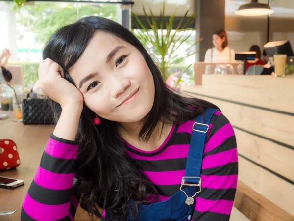 Mooie Aziatische meisje zit in café kunstwinkel — Stockfoto