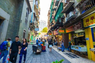 MACAU, Çin - 22 Ekim 2015 'te Macau' daki ünlü hediyelik eşya caddesini ziyaret edenler. Çinli turistler şu anda Macau turizm sektörünün ana kaynağı konumundalar..