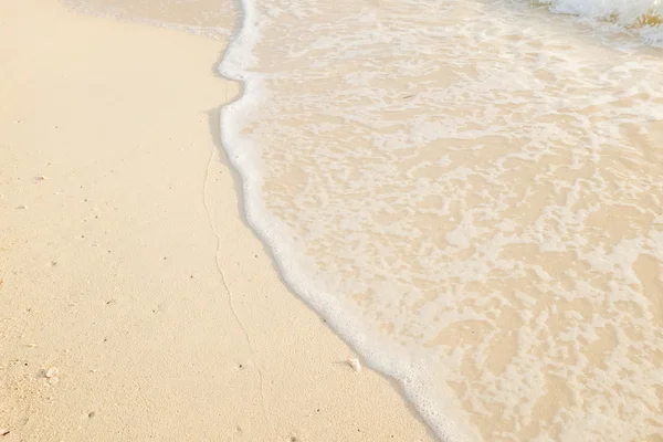 Песок пляжа с морской волной — стоковое фото