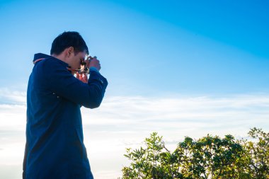 Fotoğrafçı adam kamera ile dağlarda çekmek hazırlanıyor