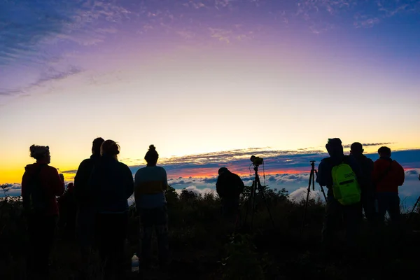 Group of tourism enjoying sunrise on top of mountain with taking photo