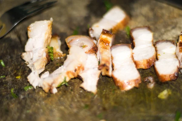 Çatal ile eski kesme tahtası üzerinde kavrulmuş domuz eti