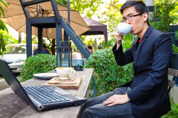 Ahşap Masa Kafede Kahve Fincan Ile Dizüstü Bilgisayar Kullanarak Asya — Stok fotoğraf