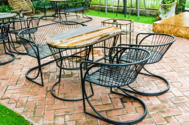 Kafenin dışındaki parkta masa ve sandalyeler ve takılma barı.