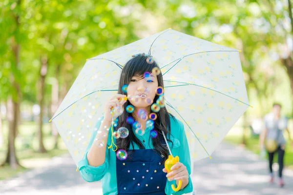Hermosa mujer joven asiática con vestido verde soplando burbuja en p —  Fotos de Stock