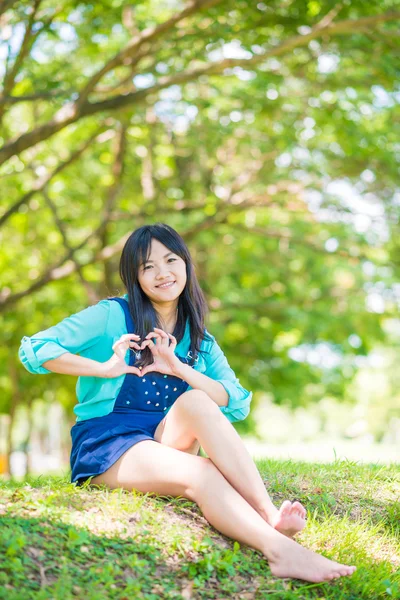 Atractiva mujer asiática relajándose en parque verde —  Fotos de Stock