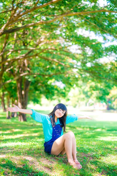Atractiva mujer asiática relajándose en parque verde —  Fotos de Stock