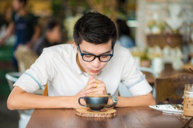 Latte sanat kahve kapalı olan Asya gülümseyen adam