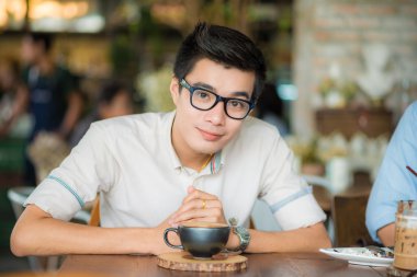 Latte sanat kahve kapalı olan Asya gülümseyen adam