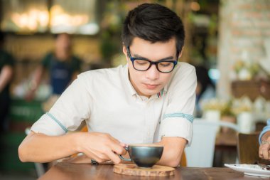 Yakışıklı işadamı kahve Cafe sanatta Asya erkeklerle içme.