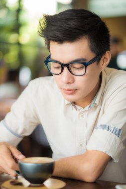 Yakışıklı işadamı kahve Cafe sanatta Asya erkeklerle içme.