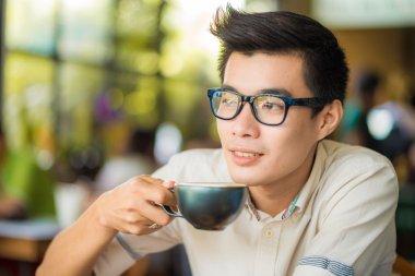 Latte sanat kahve kapalı olan Asya gülümseyen adam