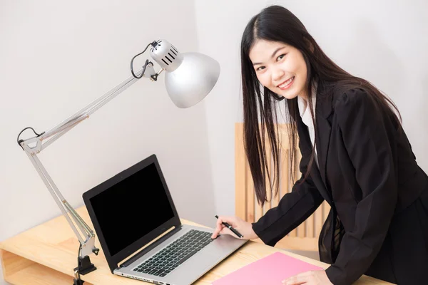 Souriant asiatique femme d'affaires avec ordinateur portable affichage en blanc — Photo