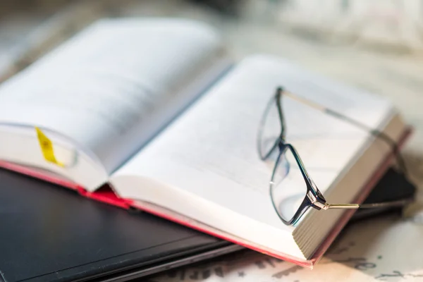 Books with a pair of glasses and computer laptop on bedroom — Stock Photo, Image