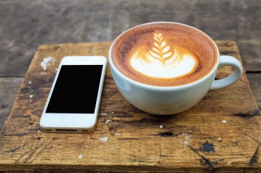 Latte sanat süt kahve ile akıllı telefon bırakın doku wo üzerinde