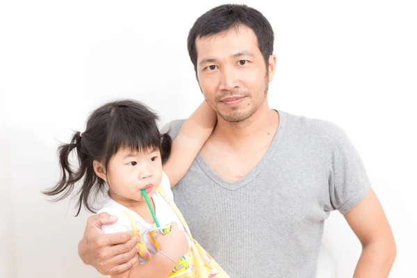 アジアの女の子はジュースを飲むと彼女の父親を抱き締める — ストック写真