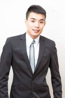 Siyah takım elbise güleryüzlü üzerinde Asya yakışıklı zeki genç iş adamı