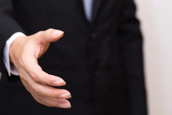 Businessman's hand sending for shake sign in black suit. — Stock Photo, Image