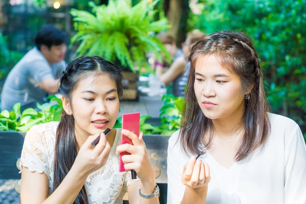 Asiática joven hermosa mujer aplicando su maquillaje con amigo —  Fotos de Stock