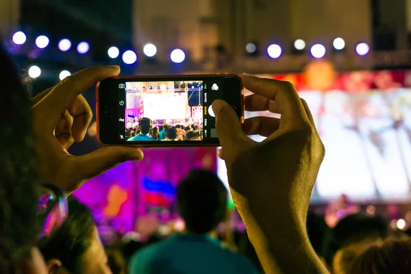 Shot of some cheering fans during a life concert take cmera recording at concert, Candid image of crowd at rock concert