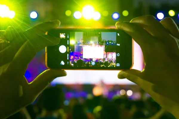 Wazig mensen houden hun slimme telefoons en fotograferen conc — Stockfoto