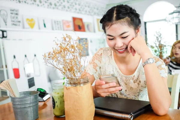 Портрет счастливой женщины, считывающей телефон с ноутбука — стоковое фото