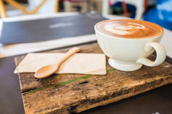 Latte art coffee cup on wood plate — Stok Foto