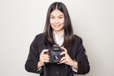 Siyah elbiseli kadın profesyonel fotoğrafçı görüntüler beyaz zemin üzerine alır.