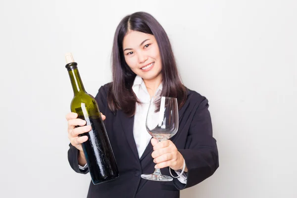 Профессиональная молодая азиатка носит черный костюм с бутылкой в руках — стоковое фото