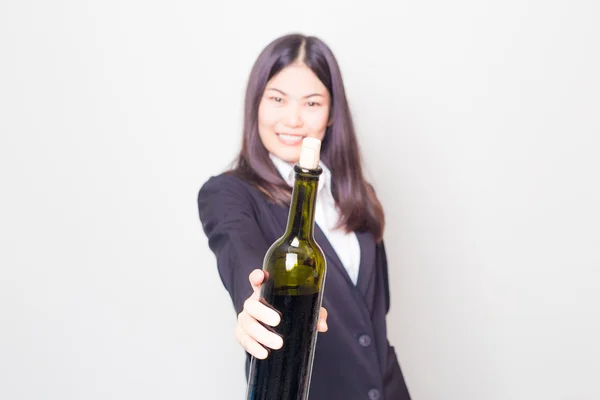 Профессиональная молодая азиатка носит черный костюм с бутылкой в руках — стоковое фото