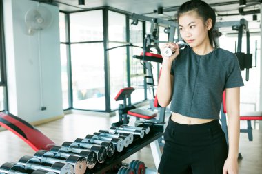 Güzel Asyalı kız fitness spor karanlık sesi de halter kaldırma spor salonunda eğitim portresi