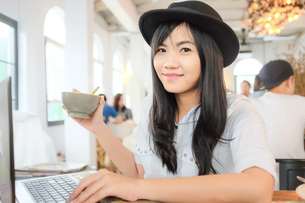 Азиатская бизнесвумен-хипстер работает на ноутбуке с чашкой кофе — стоковое фото